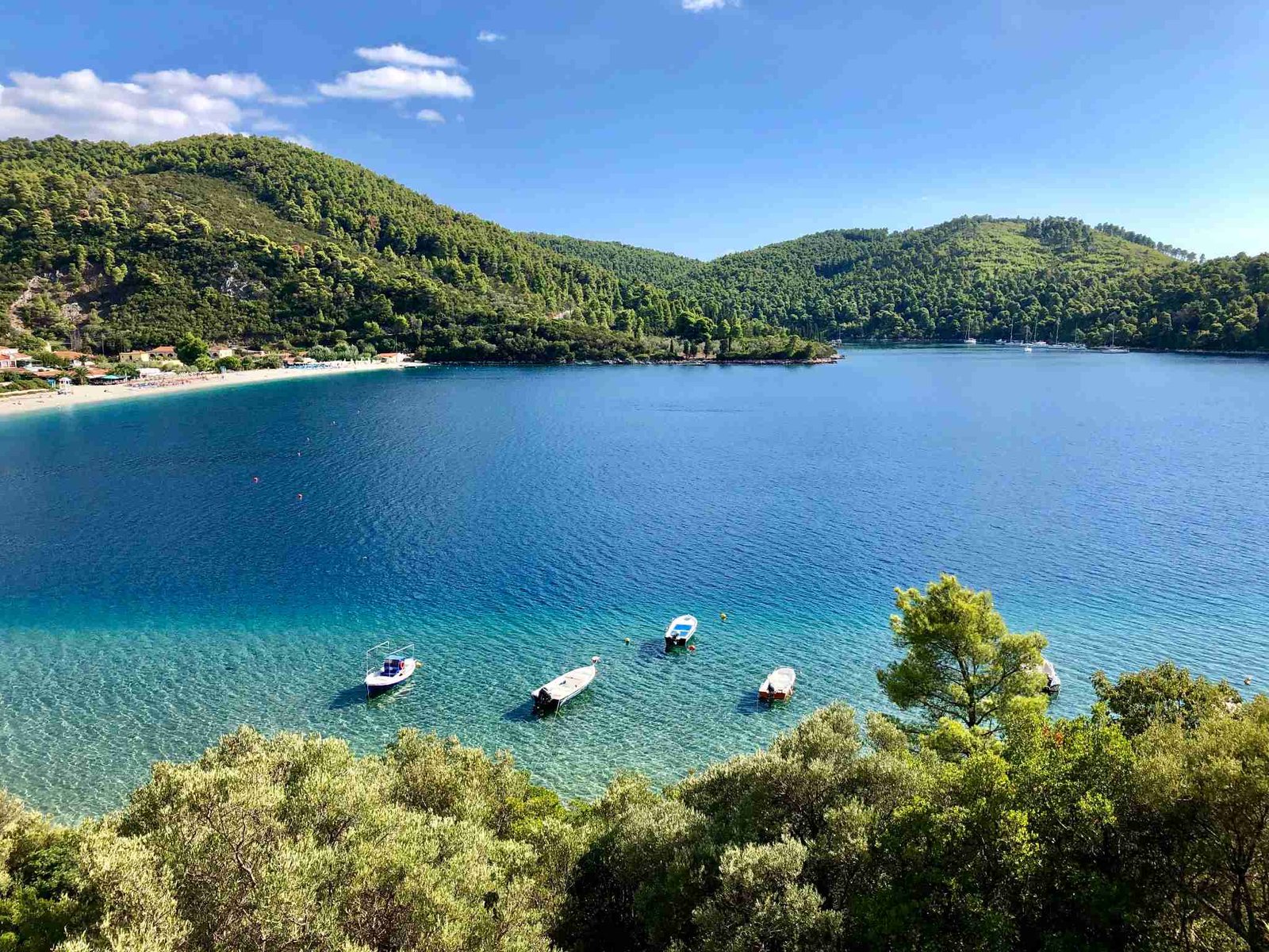 Turquoise bay on Skopelos with small boats moored near shore