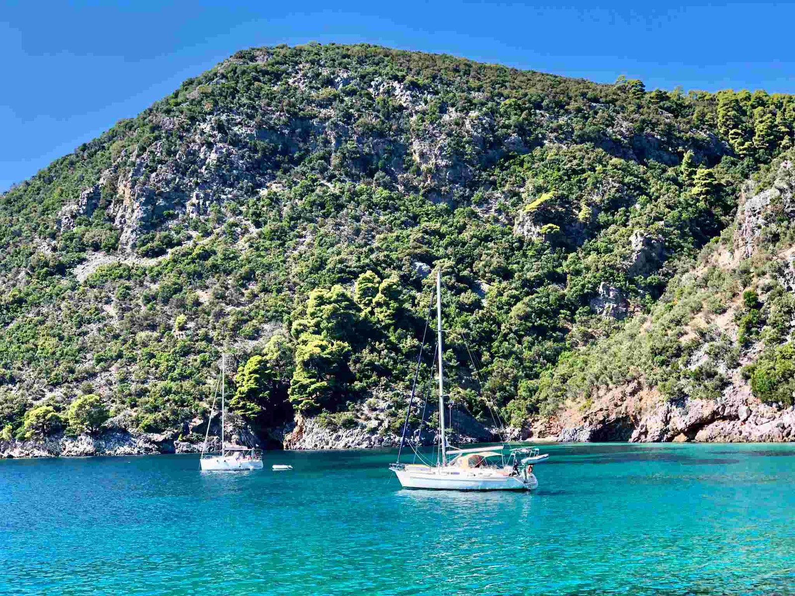 Yachts anchored in a clear turquoise cove